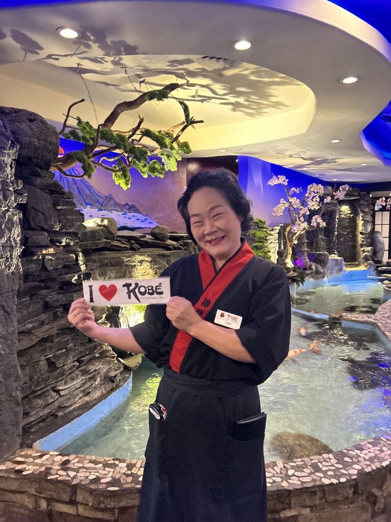 Kobe Employee holding I Love Kobe Sign