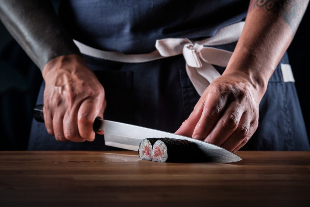 Chef using proper japanese knive skills to cut sushi